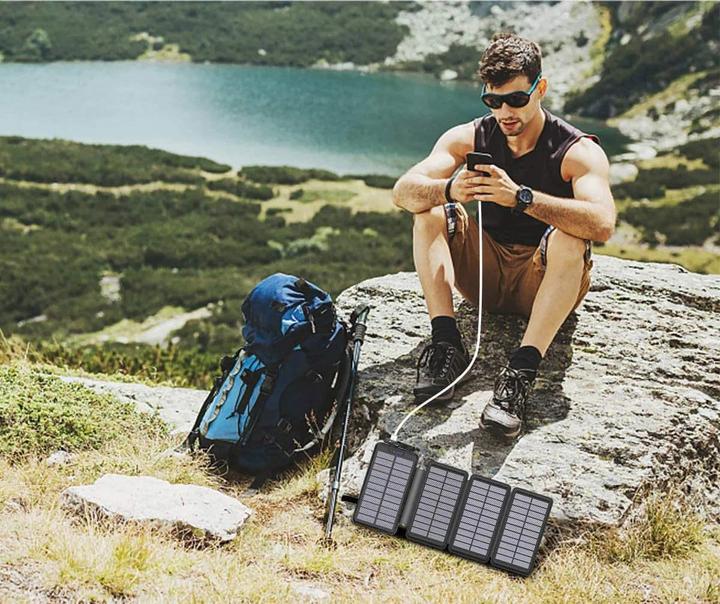 services-04 hiker charging mobile using foldable solar charger